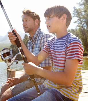 Shot of a father and son fishing together.