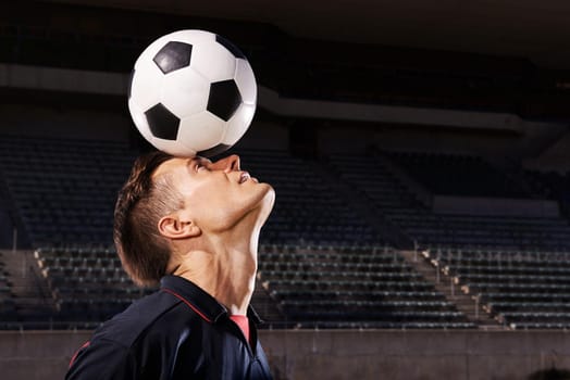 Skill and balance. Shot of a young footballer balancing a ball on his head.