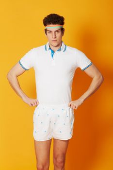 Headbands and shorts - The feel of Retro. A young male in retro tennis wear with his hands on his hips and looking at the camera.