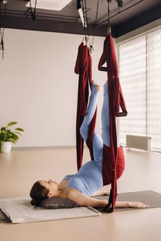Pregnant girl. A woman does yoga on a hammock in the gym. The concept of a healthy lifestyle, Motherhood.