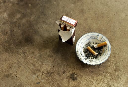 Break the habit. Shot of an ashtray, cigarette butts and a pack of cigarettes.