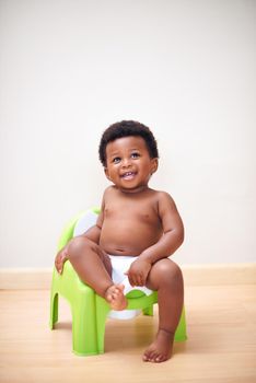 Ive got this potty training thing down. Shot of an adorable baby boy sitting on a potty training seat.