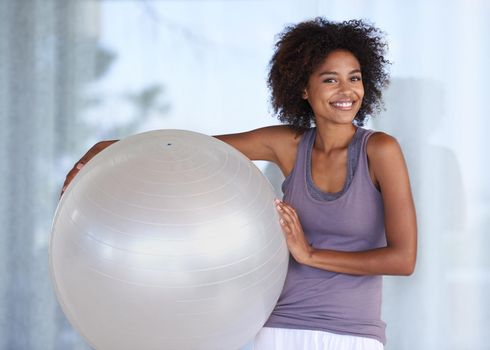 My fitness secret. Cropped portrait of an attractive young woman standing with an exercise ball.