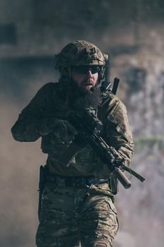 A bearded soldier in uniform of special forces in a dangerous military action in a dangerous enemy area. Selective focus
