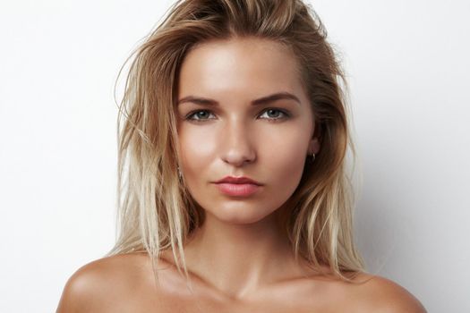 Shes got a raw sensuality. Cropped head and shoulders portrait of a sensual young blonde woman.