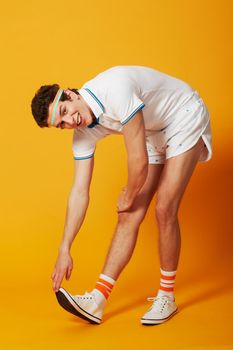 Stretch it out. A male stretching out his calf muscle in retro sports gear.