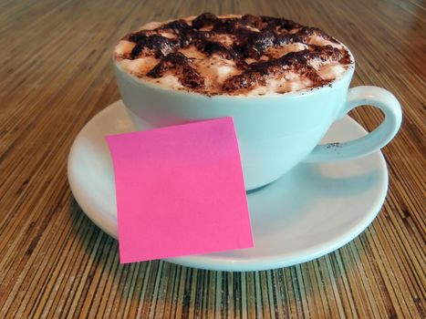 Pink note on coffee cup. Copy space. For text or messages purpose.