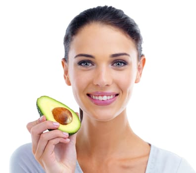 The multi talented avocado. Studio portrait of a beautiful woman holding an avocado.