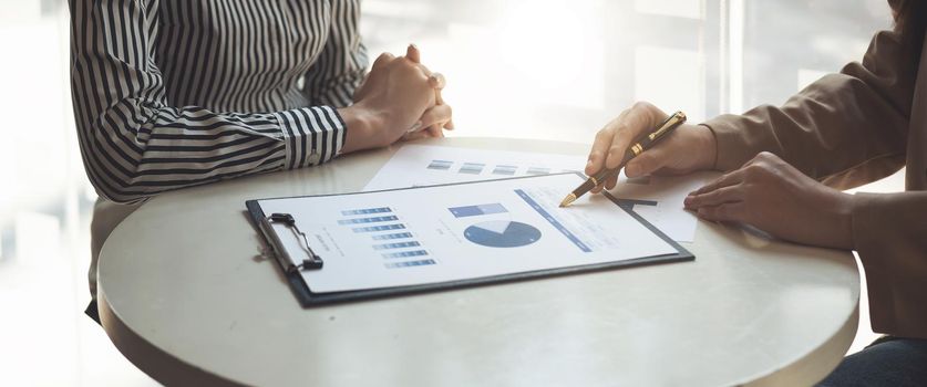 Financial Business team present. Business man hands hold documents with financial statistic stock photo, discussion, and analysis report data the charts and graphs. Finance Financial concept.