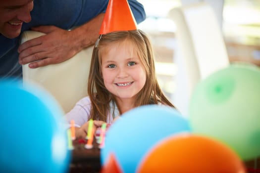 One year older and cuter too. Portrait of a happy little girl enjoying a birthday party at home.