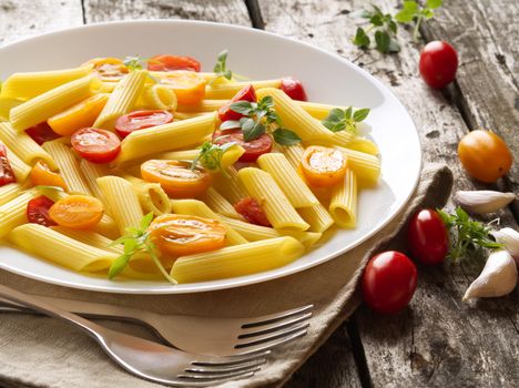 Penne pasta with tomatoes and basil on old rustic gray wooden background, low-calorie diet