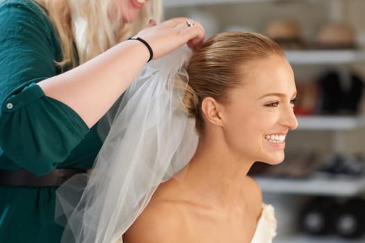 Placing those finishing touches. A young bride getting her hair done before the wedding.