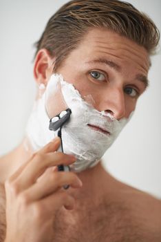 Clean shaven is best. A handsome young man shaving.