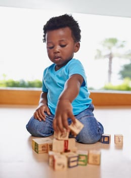 Having fun and learning all in one. Full length shot of a baby boy playing with building blocks at home.
