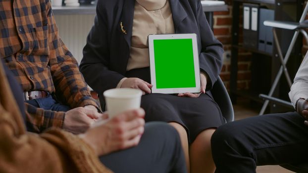 Close up of counselor vertically holding green screen on tablet at aa therapy session