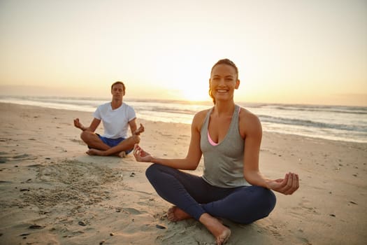 Allow nature to restore you. Portrait of a couple doing yoga on the beach at sunset.