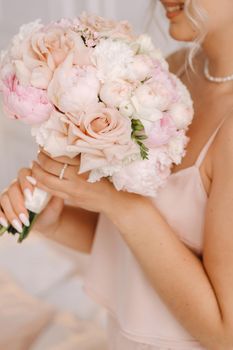 The bride holds a wedding bouquet of roses in her hands. Wedding floristry