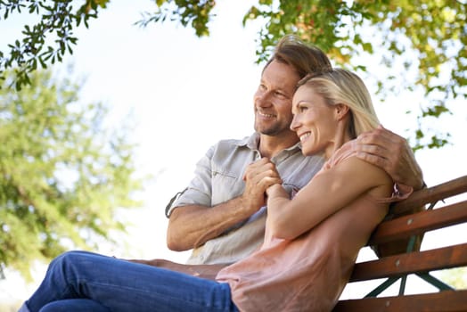 Love is inspired by the simplicity of nature. Shot of a happy mature couple sitting on a bench in the park.