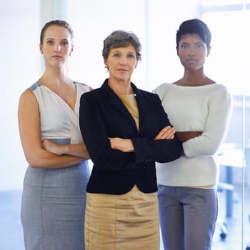 A team you can trust to deliver. A portrait of three ambitious businesswoman standing in their office.