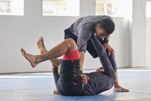 Theres a move for every scenario. Full length shot of a jiu jitsu sensei sparring with one of his students during a class.