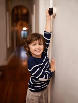 Eco conservation starts young. A cropped shot of a little boy switching a light off in his home.