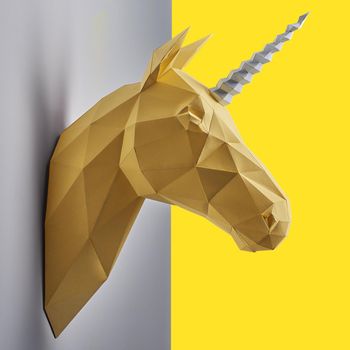 Fancy saturated yellow unicorn's head made of paper.