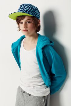 Moody blue. Cute preteen boy wearing trendy clothing while isolated on white.