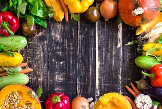 Fresh vegetables on a rustic dark textured table. Autumn background