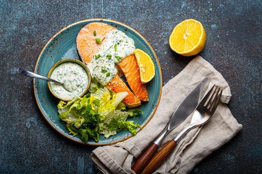 Healthy food meal cooked grilled salmon steaks with dill sauce and salad leafs on plate