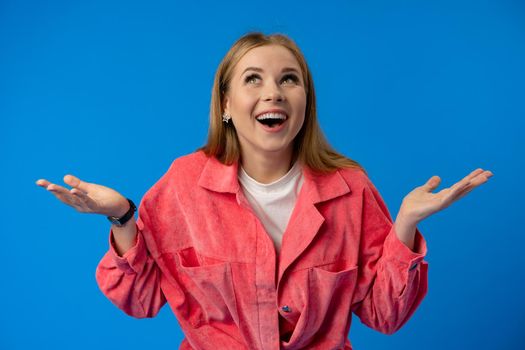 Excited thrilled woman portrait on blue studio background