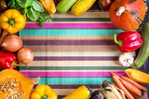 Fresh vegetables on a colorful striped kitchen towel. Autumn background