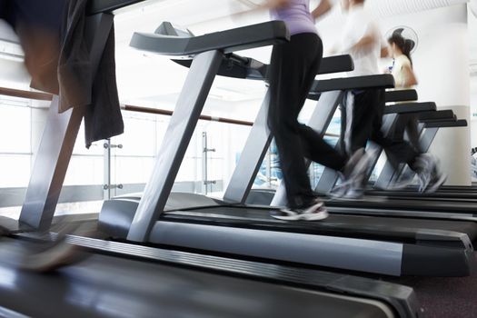 And theyre off. Cropped shot of a people running on the treadmills at the gym.