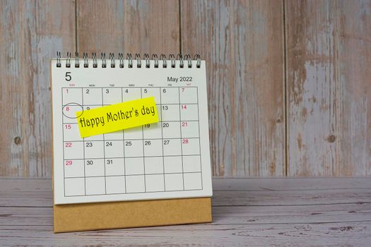 Happy Mother's Day written on stick note on white May 2022 calendar.
