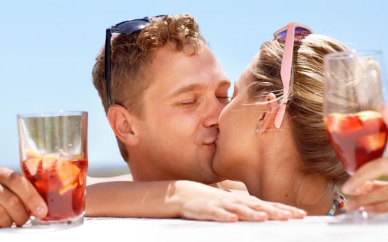 Summer love. A young couple kissing passionately in the hot summer sun.