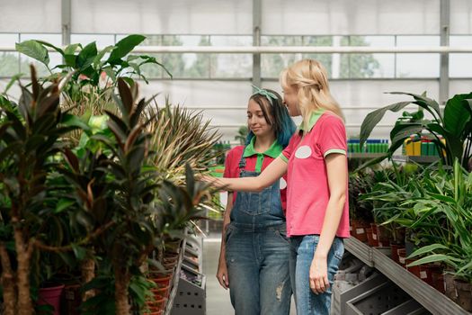 Two young women working in garden center arranging flowers