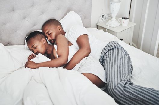 Never underestimate the power of a nap and cuddle. Shot of a happy young couple having a nap in bed together at home.