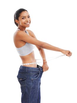 Losing weight every day. A young woman in an oversized pair of pants measuring her waist.