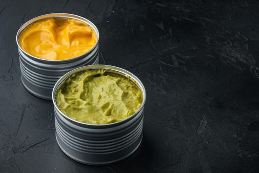 Canned guacamole and cheese dip, on black background with copy space for text