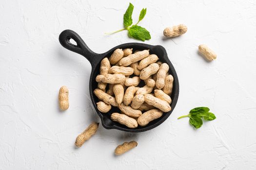 Organic peanuts in shell, on white stone table background, top view flat lay
