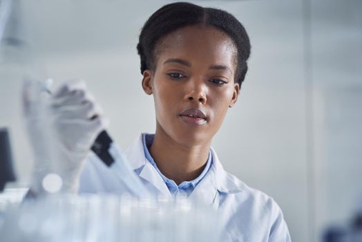 Ensuring the cure is up to standard. Shot of a young scientist working in a lab.
