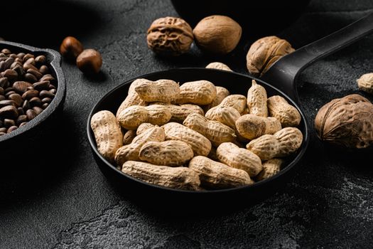 Dried peanuts. Tasty groundnuts, on black dark stone table background