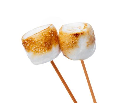 Grilled marshmallows on sticks isolated on white