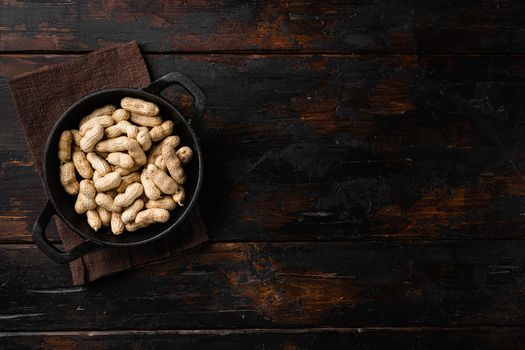 Dried peanuts. Tasty groundnuts, on old dark wooden table background, top view flat lay, with copy space for text