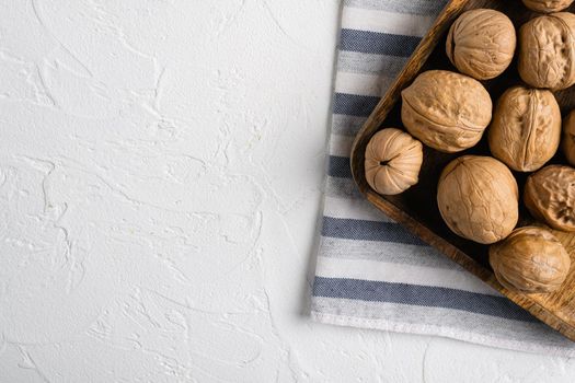 Walnuts with shells, on white stone table background, top view flat lay, with copy space for text