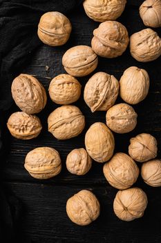 Natural walnut , on black wooden table background, top view flat lay