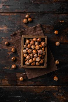 Organic Hazelnut whole nuts, on old dark wooden table background, top view flat lay, with copy space for text