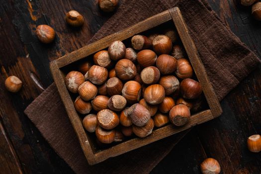 Hazelnuts brown wooden shell, on old dark wooden table background, top view flat lay