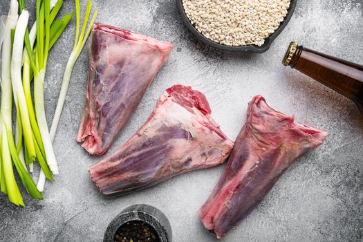Uncooked lamb shank, on gray stone table background, top view flat lay