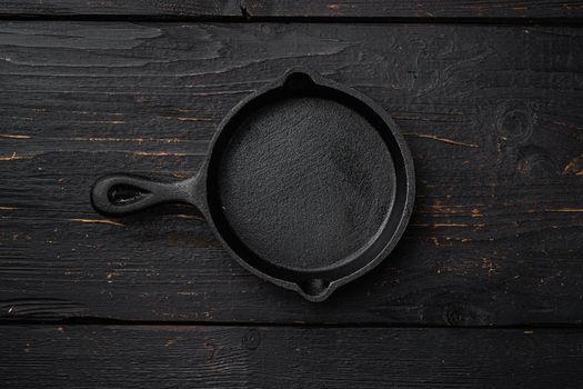 Used old empty frying pan with copy space for text or food with copy space for text or food, top view flat lay , on black wooden table background