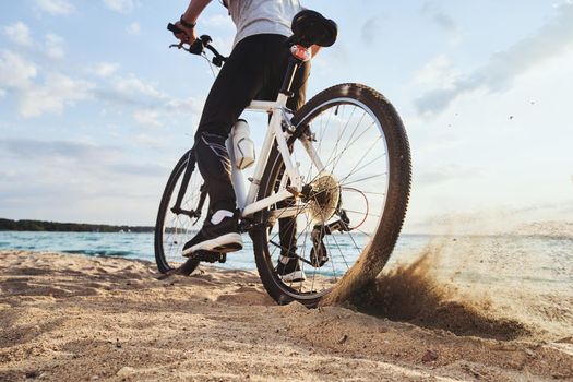 male cyclist traveling along the coastline . close-up.